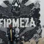 Lucas Pereira na frente de um graffiti