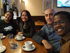 Estudantes bebendo chocolate com churros com seu professor